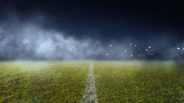 textured soccer game field with smoke - center, midfield